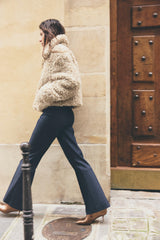 model loopt op straat met beige teddy winterjas en hakken