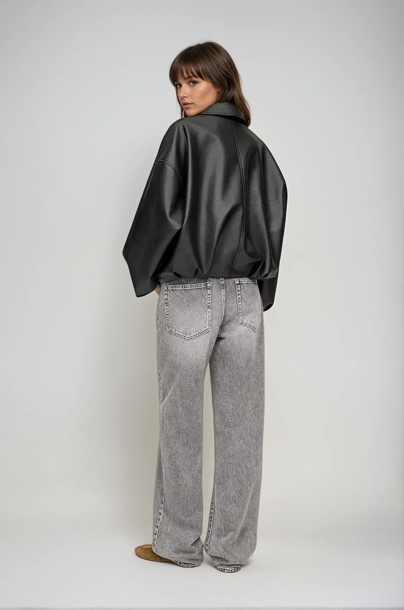 flatlay zwarte oversized jas van vegan leer met riem