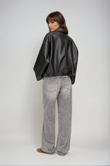 flatlay zwarte oversized jas van vegan leer met riem