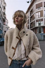 vrouw draagt beige teddy jas met knopen op straat