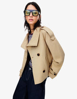 beige korte trench jas met epauletten en double-breasted knopen gedragen door vrouw