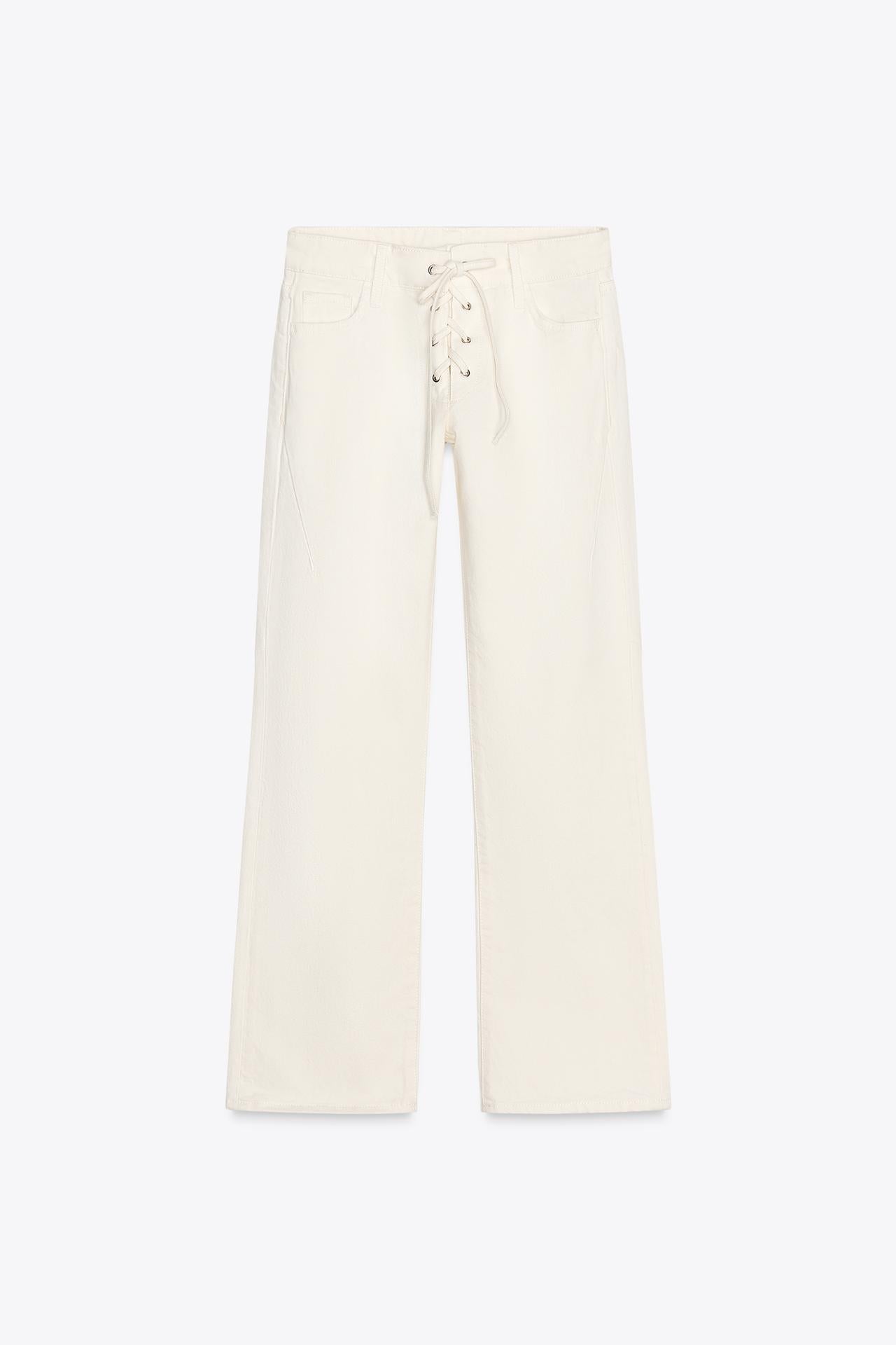 Close-up van witte rechte broek met veterdetail en zakken