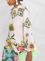 close-up van artistieke print op roze jurk met wijde mouwen