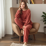 roestkleurige zachte lounge set dames met trui en broek zittend in fauteuil