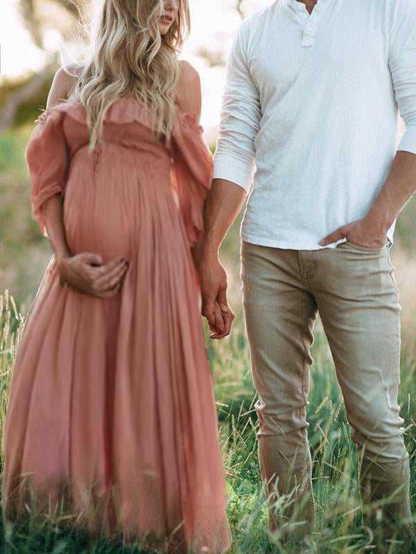 Zwangerschapsjurk off-shoulder roze buiten in het gras