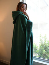 vrouw draagt lange groene hoodie blanket met teddyvoering langs de mouwen