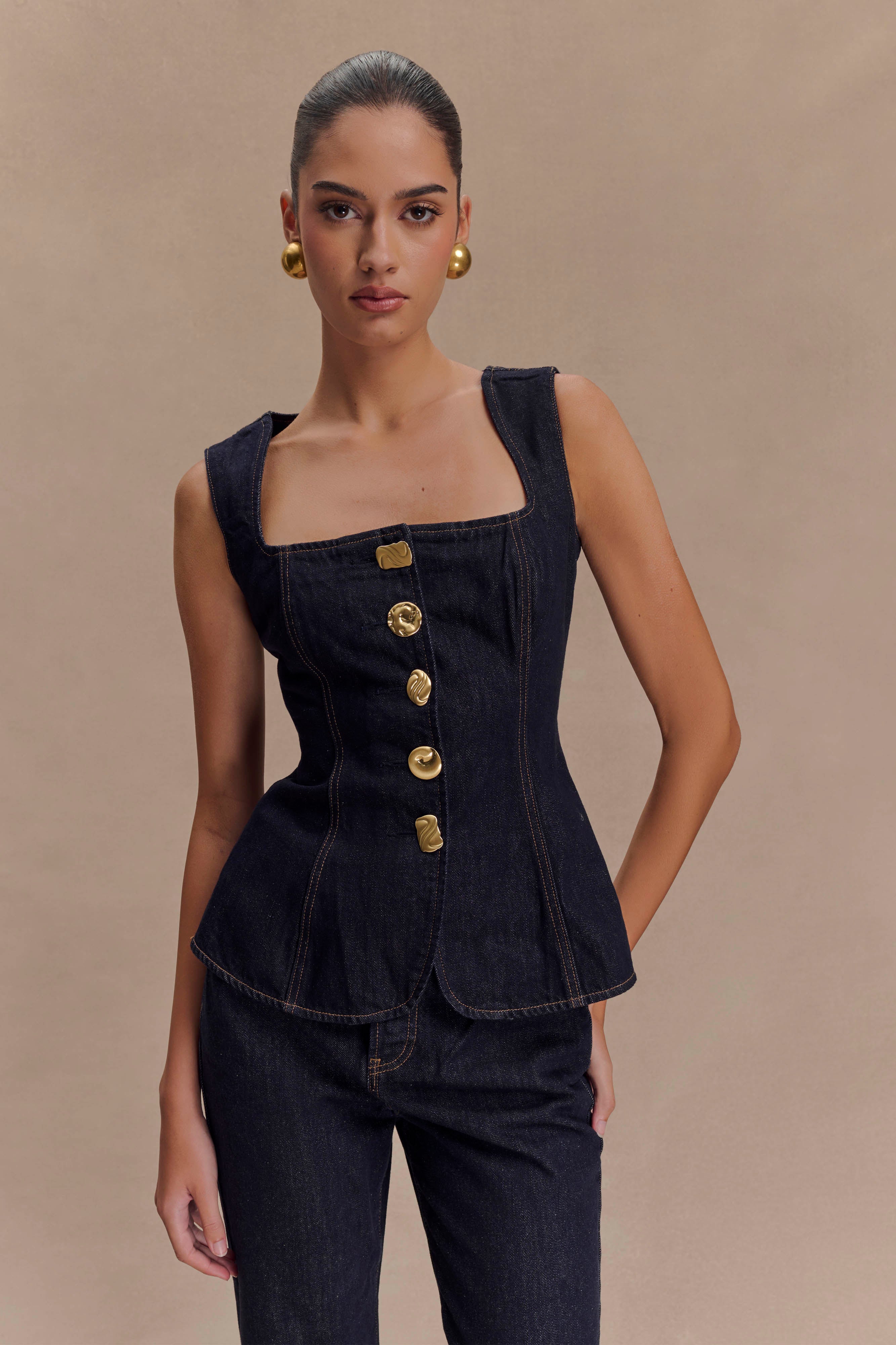 vrouwelijke denim outfit met gouden details