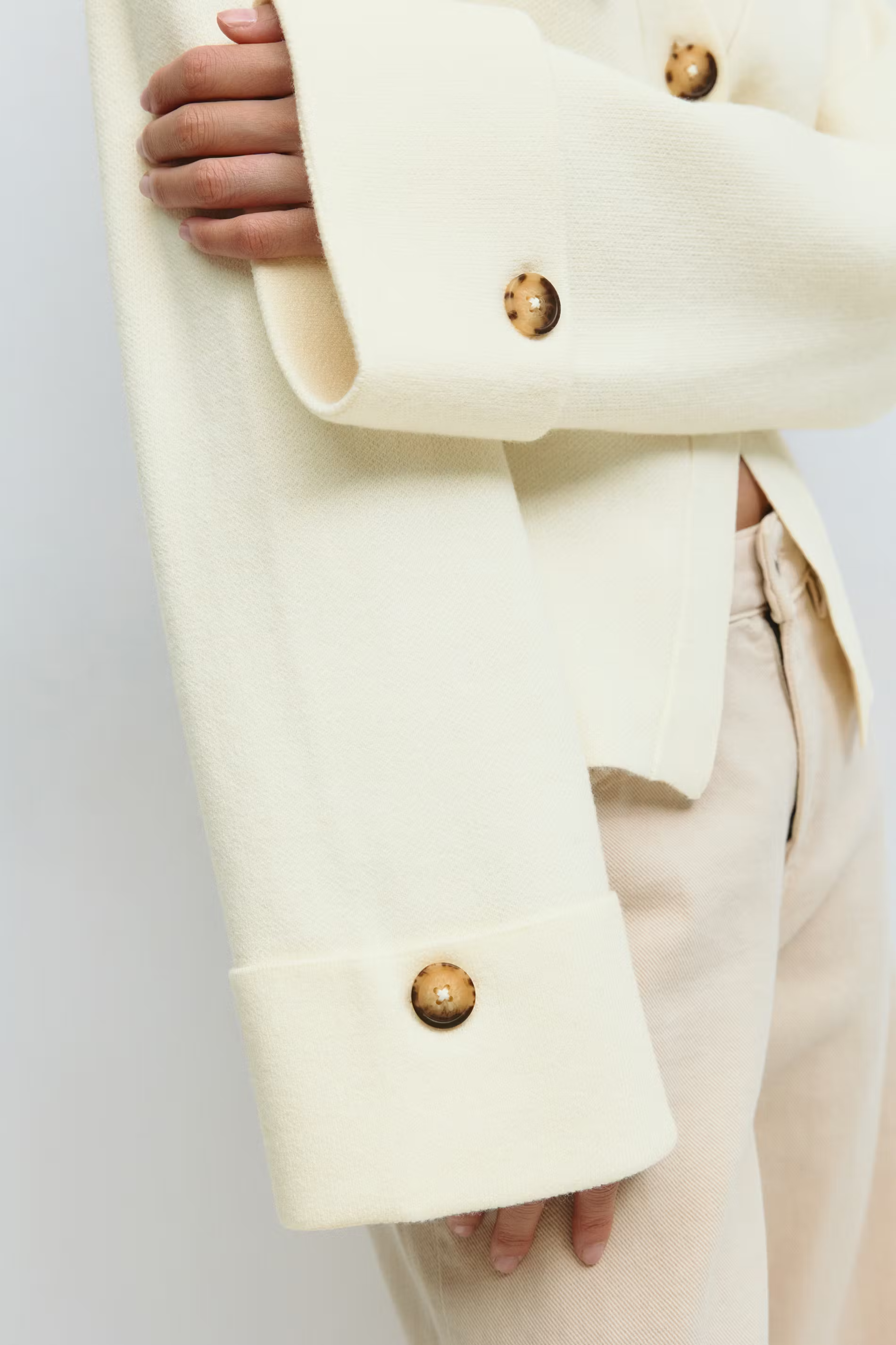 beige cardigan met knoopdetail op de mouw