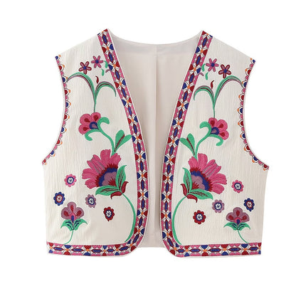 Witte gilet versierd met levendige bloemenborduursels in roze, groen en paars, met gedetailleerde geometrische randpatronen voor een bohemian en modieuze uitstraling.