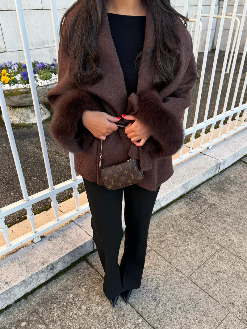 Donkerbruine winterjas met faux fur details aan de mouwen gecombineerd met laarzen
