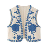 Elegante witte gilet met verfijnde blauwe bloemenborduursels en decoratieve blauwe randpatronen, perfect voor een stijlvolle en verfijnde look.