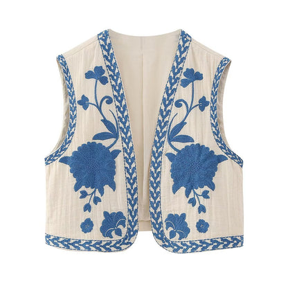 Elegante witte gilet met verfijnde blauwe bloemenborduursels en decoratieve blauwe randpatronen, perfect voor een stijlvolle en verfijnde look.