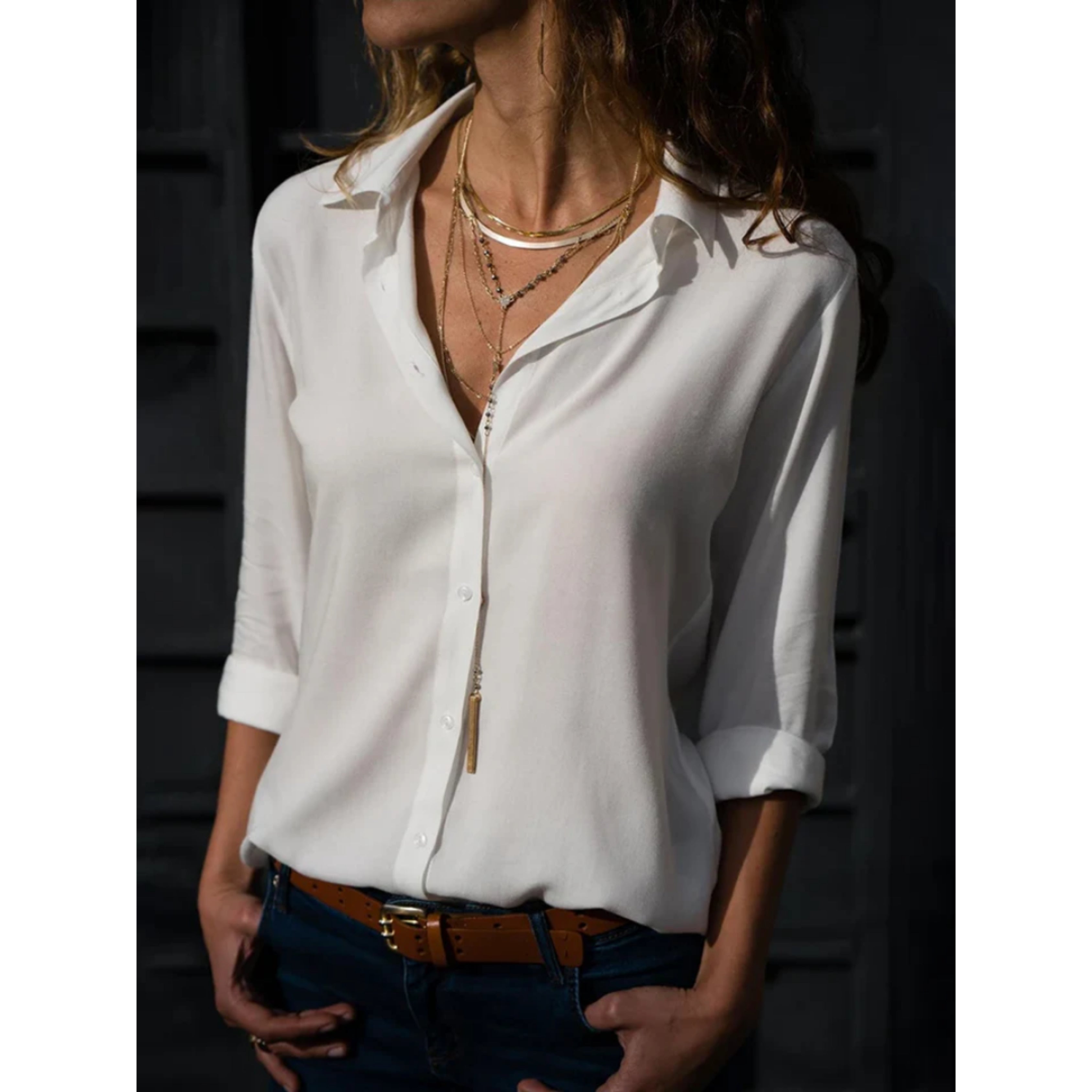 witte blouse met v-hals en opgerolde mouwen, gedragen op een jeans