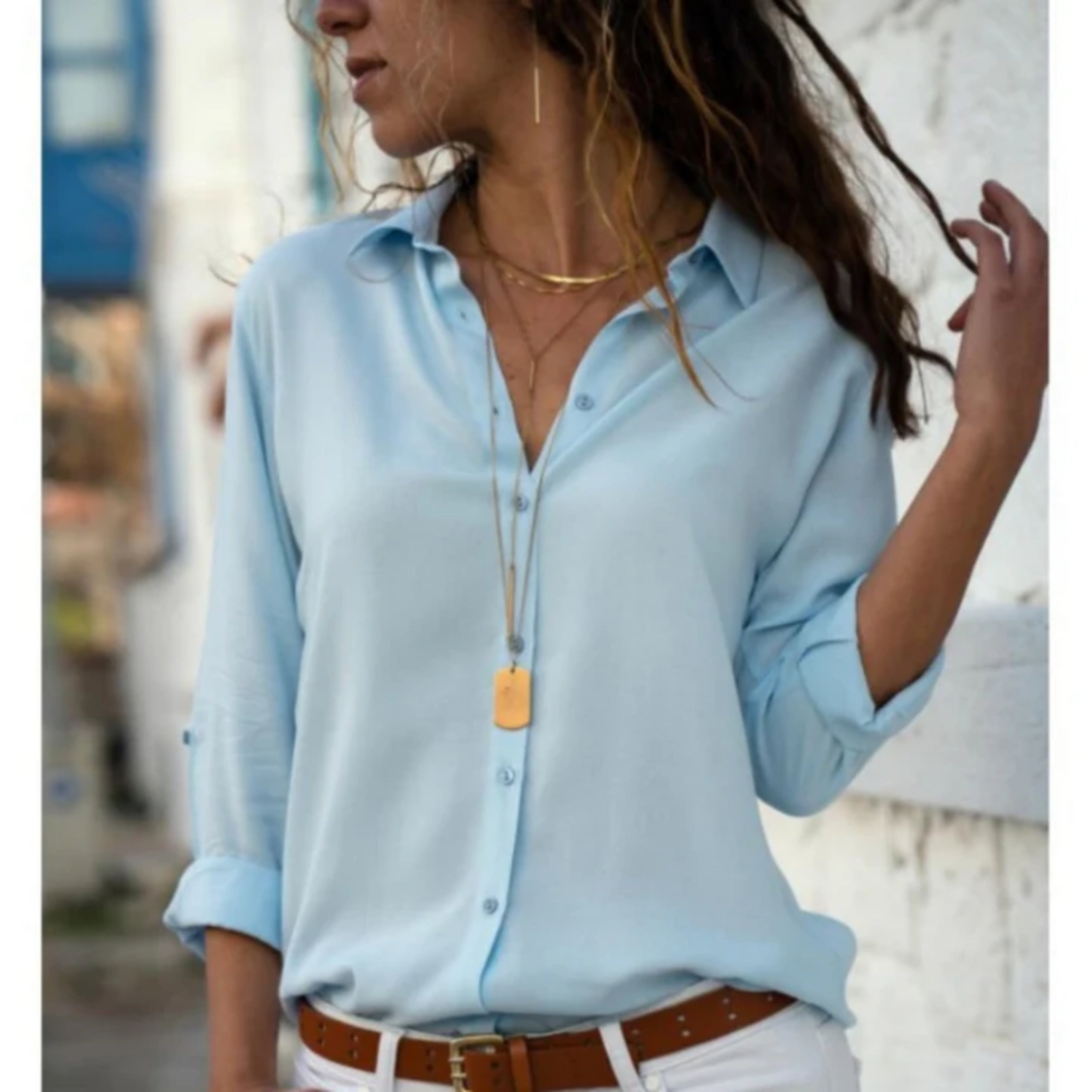 lichtblauwe blouse met v-hals en knoopsluiting, lente-look met witte jeans