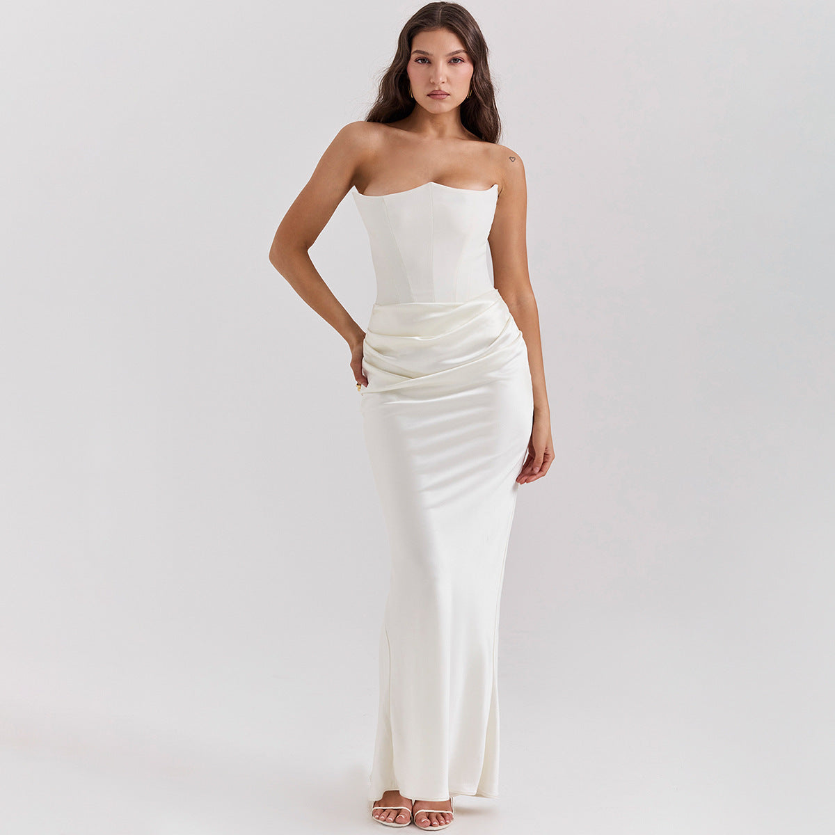 De Radiant™ Maxi Jurk is een elegante strapless avondjurk, verkrijgbaar in meerdere kleuren. Met een strakke pasvorm, gestructureerde buste en verfijnde drapering is deze jurk perfect voor formele gelegenheden, gala's en speciale evenementen. De satijnen glans voegt een vleugje luxe toe, terwijl de ritssluiting aan de achterkant zorgt voor een perfecte pasvorm. Combineer met hakken en subtiele sieraden voor een tijdloze en chique look.