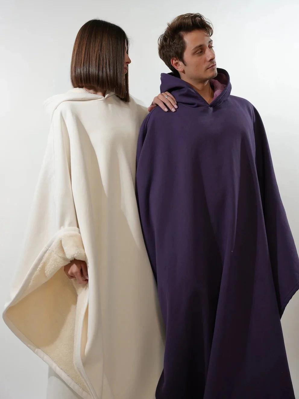 koppel draagt oversized hoodie blankets in crème en paars met teddyvoering