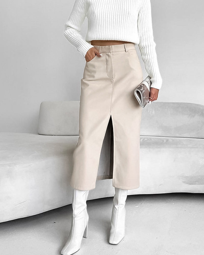 beige midi rok met split aan de voorkant, gecombineerd met witte laarzen en een witte trui