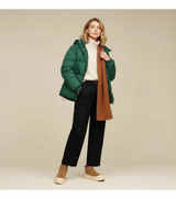 vrouw met groene jas, witte trui en bruine winter boots