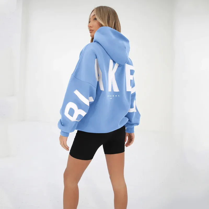 model draagt blauwe oversized trui met print op rug