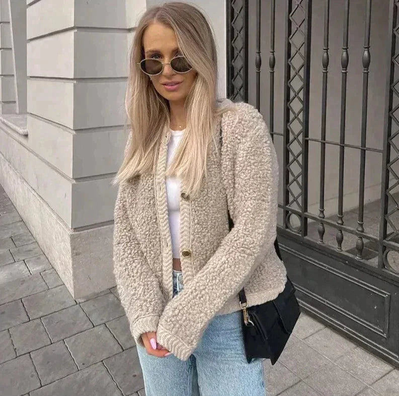 vrouw draagt beige teddy cardigan met knopen en blauwe jeans