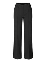 close-up van zwarte pantalon met sneakers en hoge taille