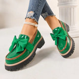 groene instappers met dikke zool en opvallend strikdetail