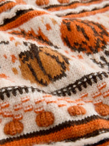 close-up van oranje en beige gebreid vest met herfstprint en knopen