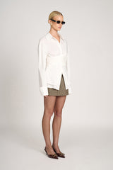 zijaanzicht van witte blouse met geplooid detail