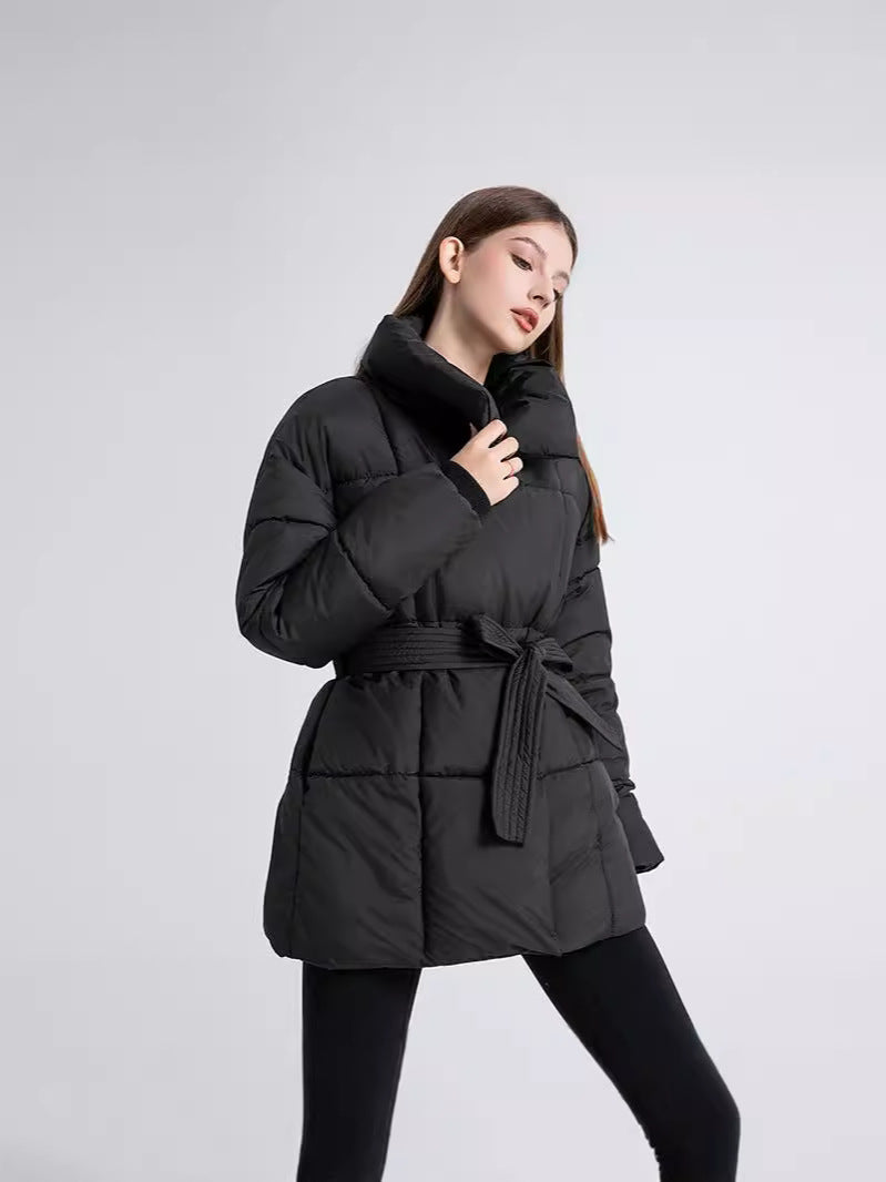 Arctic Allure Coat in zwart, gewatteerde winterjas met riem en hoge kraag voor warmte en stijl tijdens koude dagen.