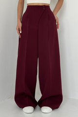 model draagt bordeauxrode wide leg pantalon met high waist en witte crop top