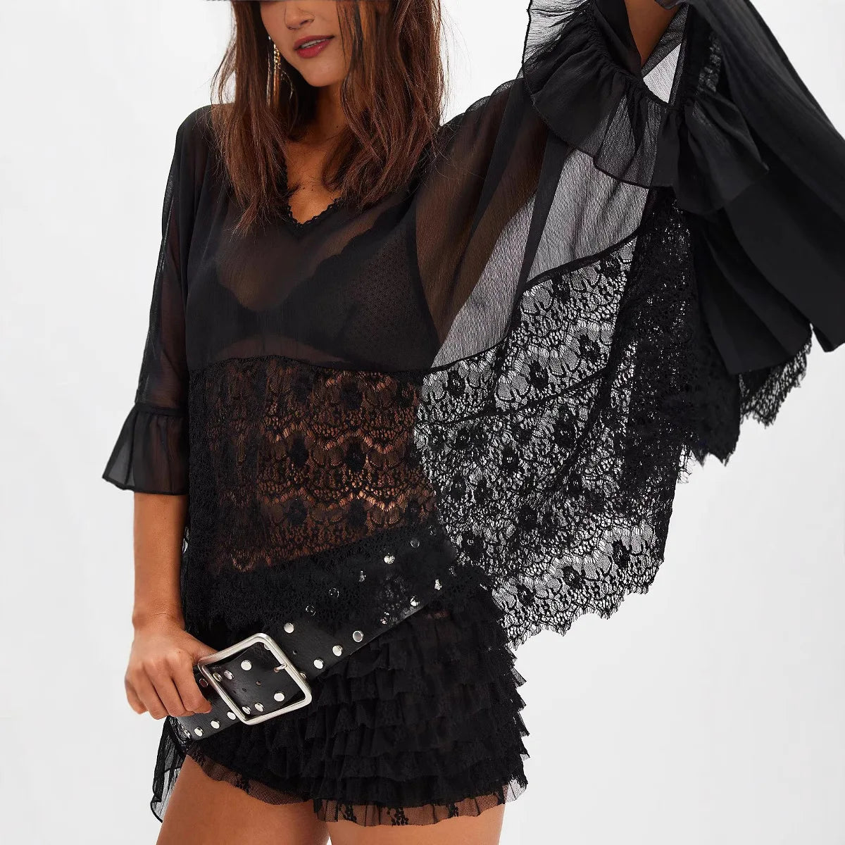 Close-up zwarte blouse met transparant kant en brede riem