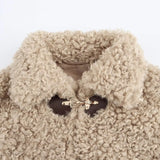 close-up van beige faux fur teddy jacket met gouden gespdetails