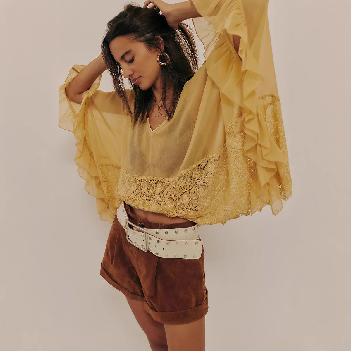 Gele blouse met kantdetails en losse fit, gestyled met een suede short