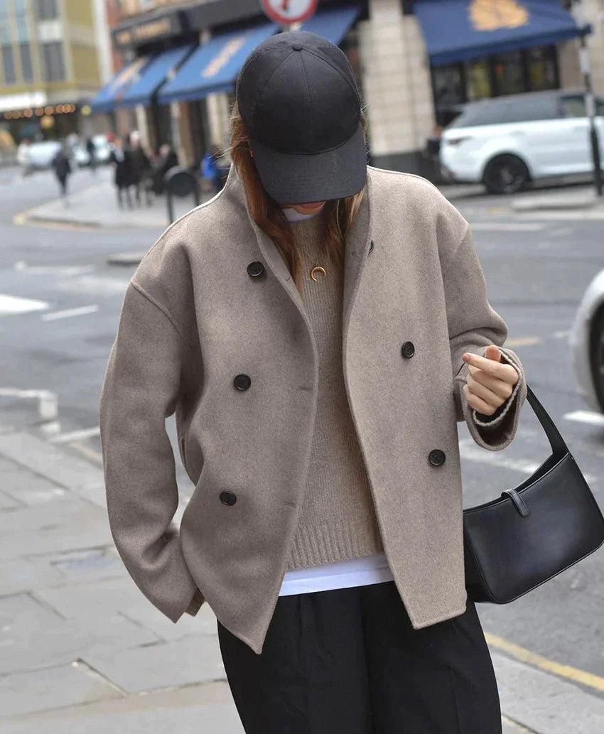 streetstyle beige oversized double breasted jas met zwarte broek en cap