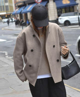 streetstyle beige oversized double breasted jas met zwarte broek en cap