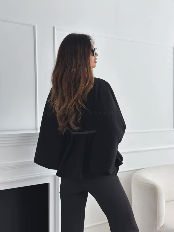 achterkant van zwarte cape top met wijde mouwen en elegante pasvorm