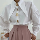 witte oversized blouse met gouden knopen gecombineerd met roze pantalon