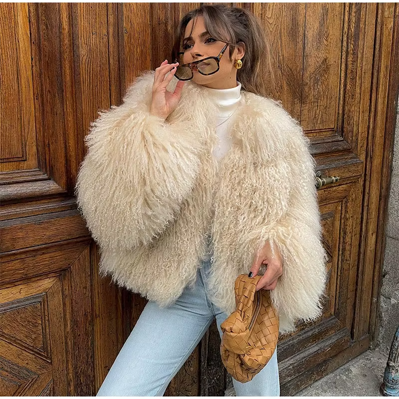 vrouw draagt beige fluffy imitatiebontjas met gevlochten tas en zonnebril
