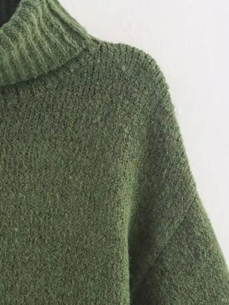 close-up van groene coltrui met ribdetail en wijde mouwen