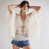 Witte blouse met kant en wijde mouwen, gecombineerd met denim shorts en strandaccessoires