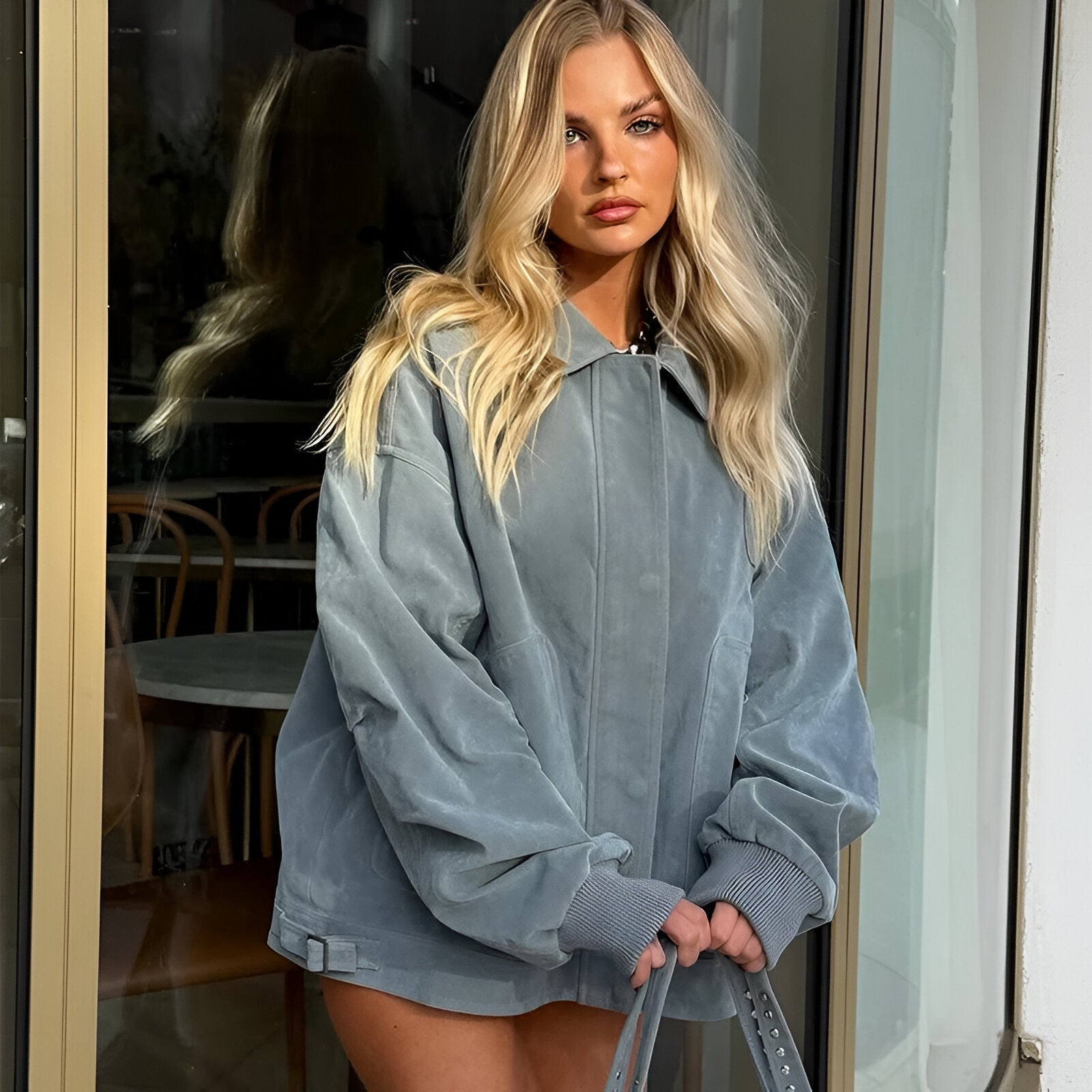 close-up model met ice blue suède-look oversized jas en verborgen drukknoopsluiting