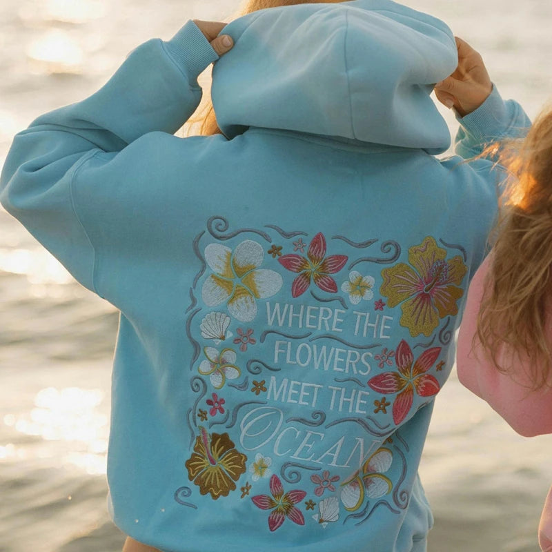 blauwe hoodie met geborduurde bloemen en tekst