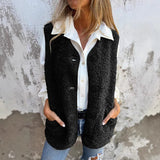 zwarte teddy gilet voor dames met knopen en zakken, gecombineerd met witte blouse en jeans