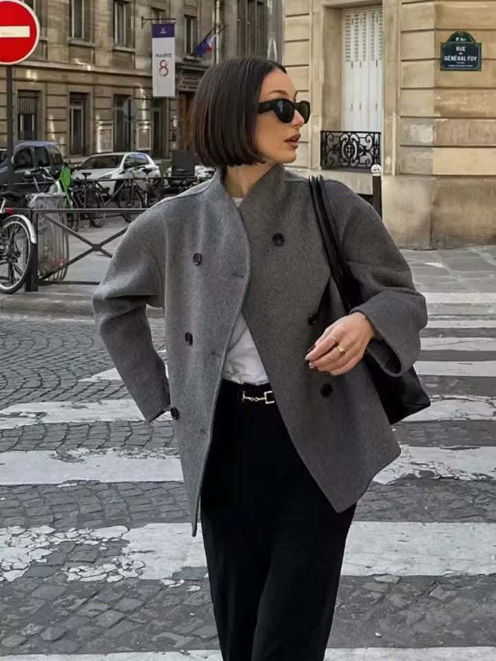 model draagt grijze oversized jas op straat met casual styling