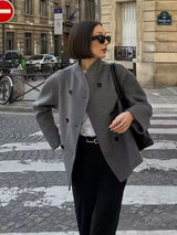 model draagt grijze oversized jas op straat met casual styling