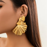 Grote goudkleurige statement oorbellen met sculpturaal design