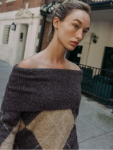 vrouw draagt casual off-shoulder argyle trui tijdens wandeling in de stad