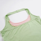 Detail van de halterhals met roze contrast van de matcha groene sporttop voor dames