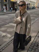 vrouw met beige double breasted jas en leren handtas city look