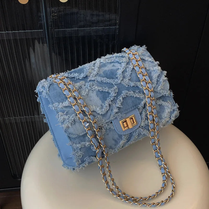 blauwe tas van denim met ruwe afwerking en draaiknop